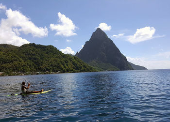 Scenic view of sea by mountains against sky