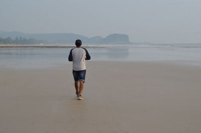 Rear view of man standing on beach