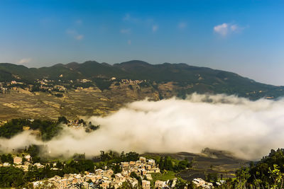 Aerial view of townscape and mountains against sky