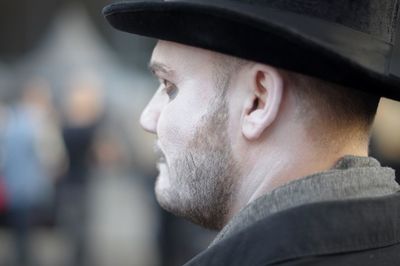 Close-up of man with face paint wearing hat standing outdoors