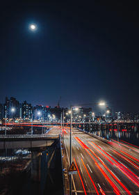 Light trails on road against sky at night