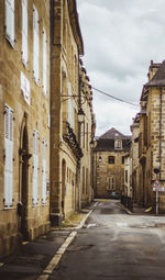 Street amidst buildings in city against sky