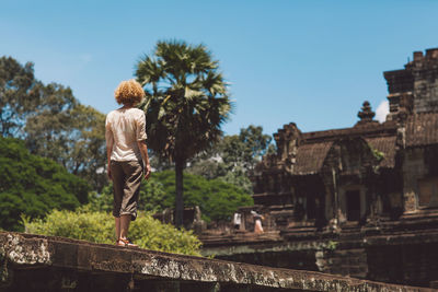 Woman standing on bridge against historical building