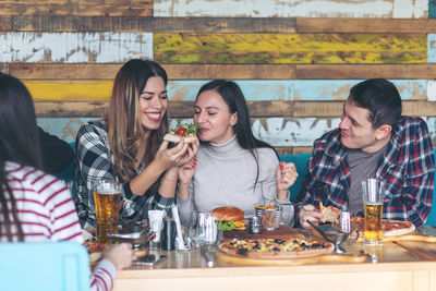 Happy friends having food at table in restaurant