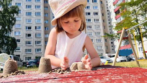 Small girl playing at playground at backyard of blocks of flats
