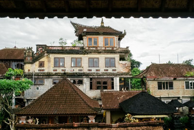 Facade of old building in town against sky