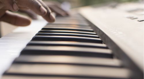 Close-up of hand over piano keys