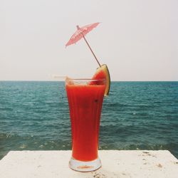 Glass of watermelon juice at seashore