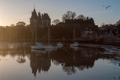 Sailboats moored in lake against buildings