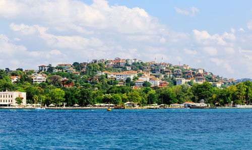 Scenic view of sea by town against sky