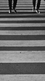 Low section of people walking on zebra crossing