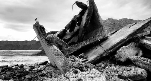 Abandoned boat on beach against sky