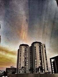 Low angle view of buildings against cloudy sky