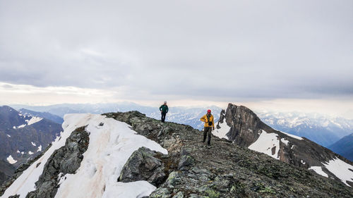 People on snowcapped mountain against sky