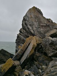 Close-up of rock formation by sea against sky