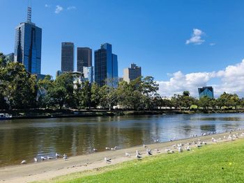 Scenic view of yarra river by buildings against sky