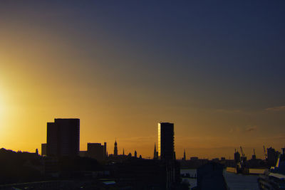 Silhouette buildings against sky during sunset