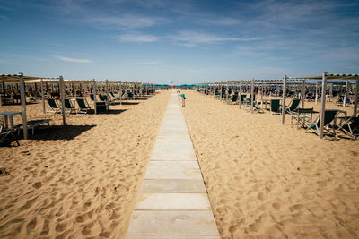 People walking on beach against sky