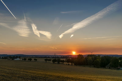 Scenic view of agricultural field against sky during sunset