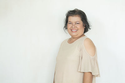 Portrait of smiling young woman against white background