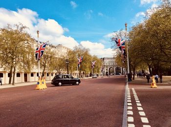 Cars on road in city against sky