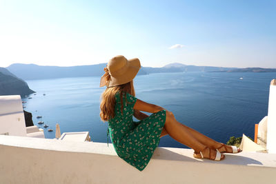 Rear view of woman looking at sea against sky