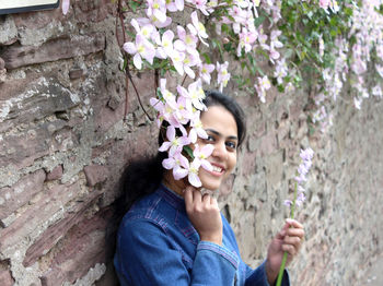 Portrait of a smiling young woman holding flowering plants