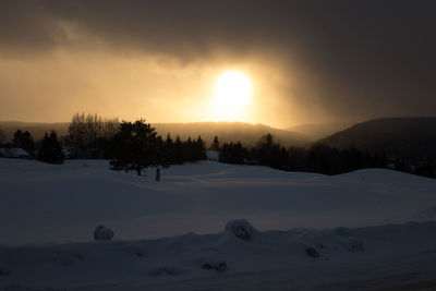 Scenic view of snowy landscape against sky during sunset