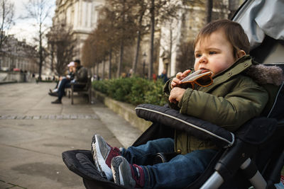 Side view of siblings sitting on seat