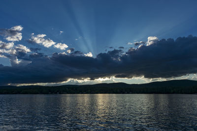 Scenic view of lake by mountains against sky