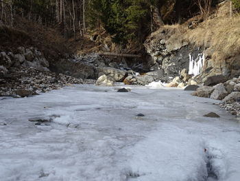 Stream flowing through rocks in winter