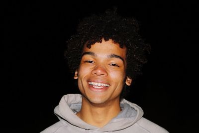 Portrait of a smiling man against black background