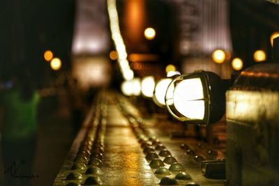 Illuminated lights on bridge railing at night