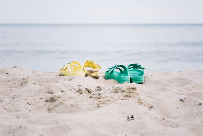 Two pairs of sandals on a sandy beach in summer