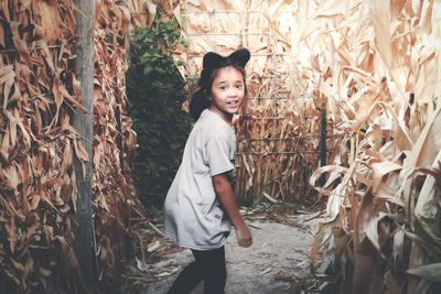 Portrait of girl standing amidst crops