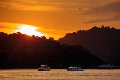 Scenic view of silhouette trees against orange sky