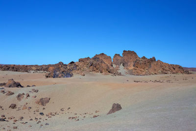 Scenic view of desert against clear blue sky