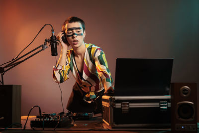 Portrait of young man using mobile phone at music concert