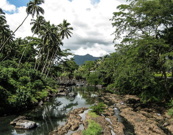 Scenic view of river against cloudy sky