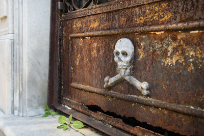 Close-up of statue against old door