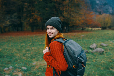 Young woman wearing hat standing on field during autumn