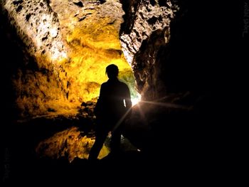 Silhouette person standing on rock formation