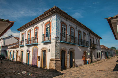 Overview of cobblestone street with old houses under blue sunny sky in paraty, brazil