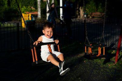 Portrait of smiling girl swinging in playground