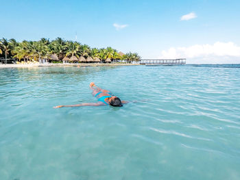 Woman swimming in sea against sky