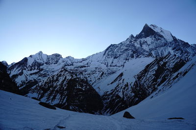 Scenic view of snowcapped mountains against clear blue sky