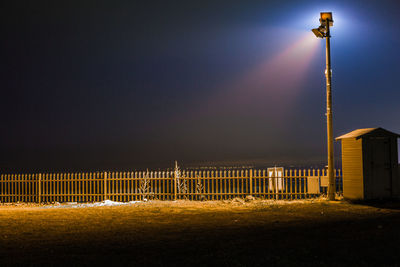 Illuminated fog against sky at night