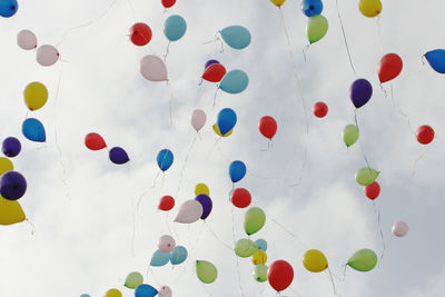 Low angle view of balloons flying against sky