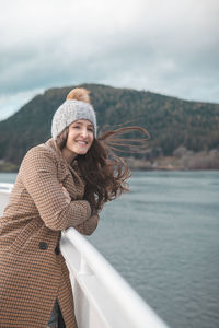 Woman wearing warm clothing standing in boat on sea