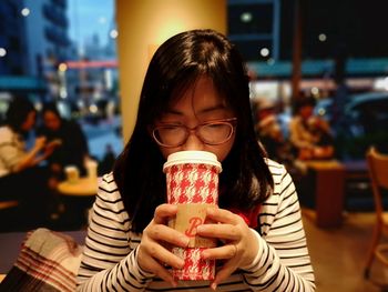 Portrait of woman drinking coffee in restaurant